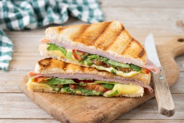 Jambonlu, peynirli, domatesli ve roka aromalı sandviç.