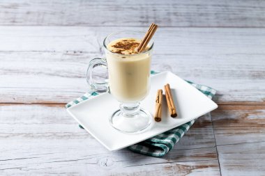 Tarçın ahşap masa üzerinde ev yapımı yumurta likörü. Tipik Noel tatlısı. 