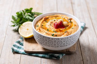 Ahşap masada kavrulmuş kırmızı biber humusu.