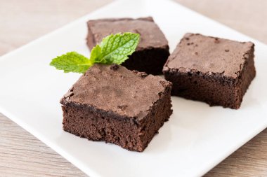 Çikolatalı brownie porsiyonu ahşap masada.
