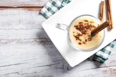 Ahşap masada tarçınlı ev yapımı eggnog. Tipik Noel tatlısı. Boşluğu kopyala