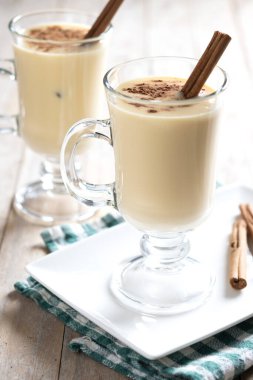 Ahşap masada tarçınlı ev yapımı eggnog. Tipik Noel tatlısı. Kapat.