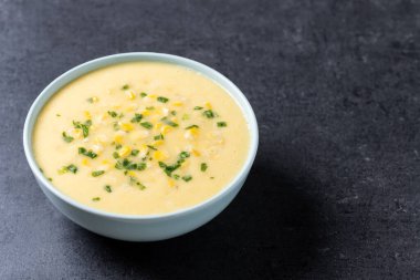 Siyah arka planda beyaz kasede mısır çorbası. Boşluğu kopyala