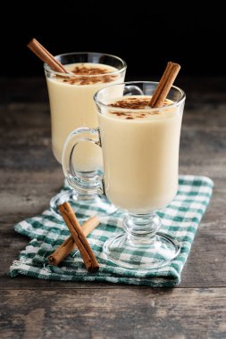 Tarçın ahşap masa üzerinde ev yapımı yumurta likörü. Tipik Noel tatlısı. 