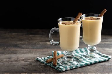 Ahşap masada tarçınlı ev yapımı eggnog. Tipik Noel tatlısı. Boşluğu kopyala