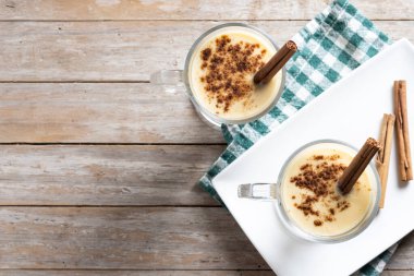 Ahşap masada tarçınlı ev yapımı eggnog. Tipik Noel tatlısı. Süper manzara. Boşluğu kopyala