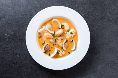 Siyah arka planda deniz ürünleri çorbası.