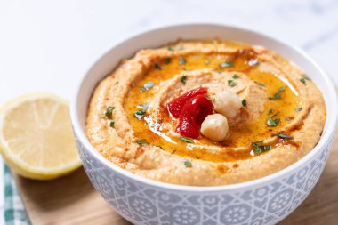 Beyaz mermer arka planda kavrulmuş kırmızı biber humusu.