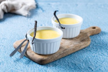 Mavi arka planda ev yapımı vanilyalı krema.