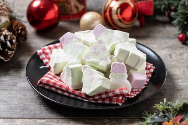 Noel ağacı ve ahşap masada kardan adam şekilli Noel şekeri.