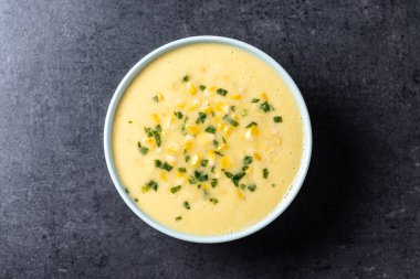 Siyah arka planda yeşil kasede mısır çorbası. Üst görünüm