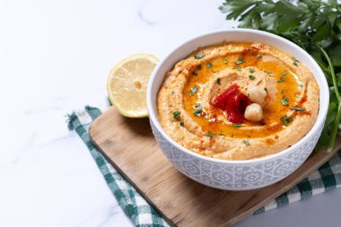 Beyaz mermer arka planda kavrulmuş kırmızı biberli humus. Boşluğu kopyala