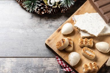 Geleneksel Noel tatlısı, noel tatlısı ve ahşap masada tatlı bademler.