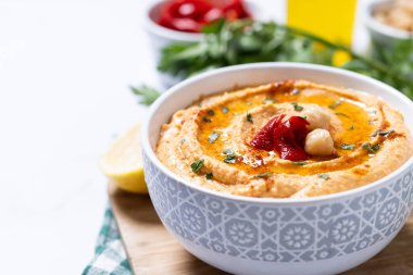 Beyaz mermer arka planda kavrulmuş kırmızı biberli humus. Boşluğu kopyala