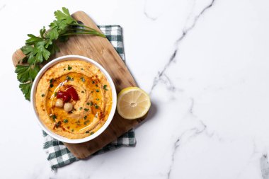 Beyaz mermer arka planda kavrulmuş kırmızı biberli humus. Üst Manzara. Boşluğu kopyala