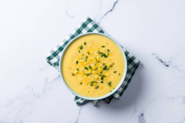 Yeşil kasede beyaz mermer üzerinde mısır çorbası