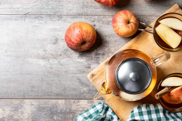 Sonbahar sıcak elma suyu ve ahşap masada baharatlar.