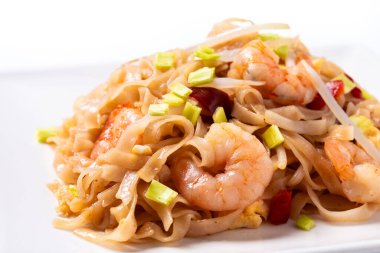 Beyaz arka planda karides ve sebzeli Pad Thai. Geleneksel Tayland yemekleri