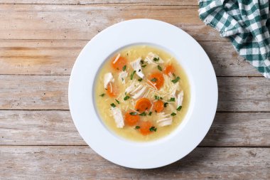 Tahta masada sebzeli tavuk çorbası. Üst görünüm