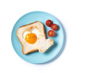 Domatesli yumurta, kalp şeklinde ekmek ve beyaz arka planda izole edilmiş tost ekmeğiyle Sevgililer Günü kahvaltısı.