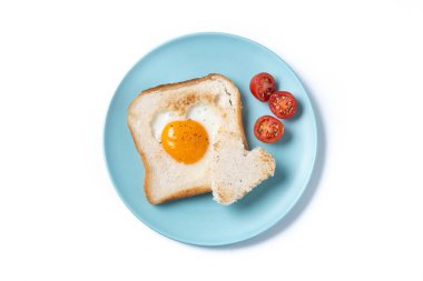 Domatesli yumurta, kalp şeklinde ekmek ve beyaz arka planda izole edilmiş tost ekmeğiyle Sevgililer Günü kahvaltısı.
