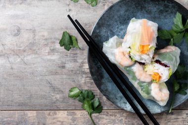 Vietnam börekleri, sebzeli, pirinç erişteli ve karidesli ahşap masa. Boşluğu kopyala