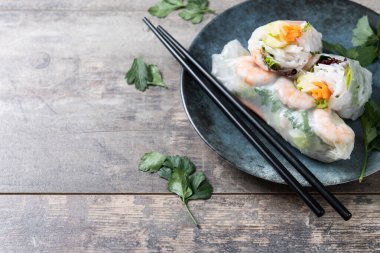 Vietnam börekleri, sebzeli, pirinç erişteli ve karidesli ahşap masa. Boşluğu kopyala