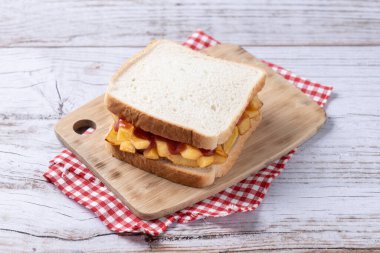 Geleneksel İngiliz cipsi Butty (patates kızartması sandviçi) ahşap masada.