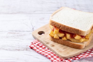 Geleneksel İngiliz cipsi Butty (patates kızartması sandviçi) ahşap masada.