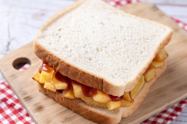 Geleneksel İngiliz cipsi Butty (patates kızartması sandviçi) ahşap masada.