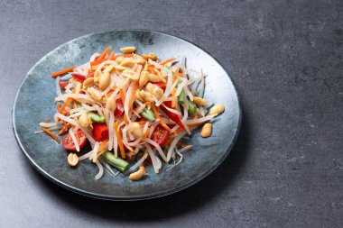 Yeşil Papaya Salatası, siyah arka planda som tam Thai.