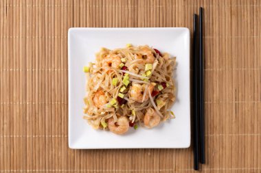 Tahta masada karides ve sebzeli Pad Thai.