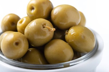 Beyaz arka plan üzerinde izole beyaz kase yeşil zeytin.