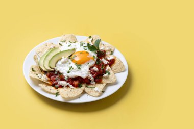 Geleneksel Meksika kahvaltısı kırmızı biberli ve sarı arka planda yumurta. Boşluğu kopyala