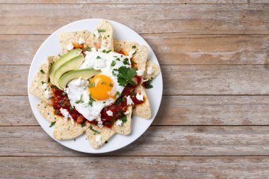Geleneksel Meksika kahvaltısı kırmızı biberli ve ahşap masada yumurta. Üst Manzara. Boşluğu kopyala