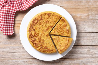 Geleneksel İspanyol omleti ve ahşap masa malzemeleri. Üst görünüm