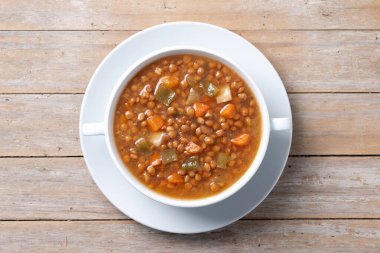 Tahta masada sebzeli mercimek çorbası. Üst görünüm