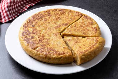 Siyah arkaplanda geleneksel İspanyol omleti. 