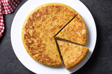 Siyah arka planda geleneksel İspanyol omleti. Üst görünüm. 