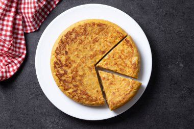 Siyah arka planda geleneksel İspanyol omleti. Üst görünüm. 