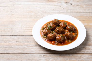 Köfte, yeşil bezelye ve ahşap masada domates soslu havuç. Boşluğu kopyala