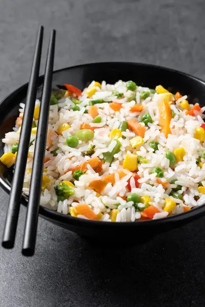 Weißer Reis Mit Gemüse Einer Schwarzen Schüssel Auf Schwarzem Hintergrund lizenzfreie Stockfotos