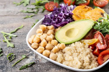 Tahta masada avokado, marul, domates ve nohut ile sağlıklı salata. Boşluğu kopyala