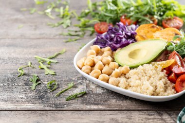 Tahta masada avokado, marul, domates ve nohut ile sağlıklı salata. Boşluğu kopyala