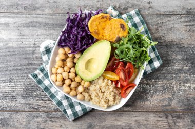 Tahta masada avokado, marul, domates ve nohut salatası.