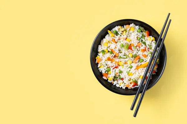 Weißer Gebratener Reis Mit Gemüse Einer Schwarzen Schüssel Auf Gelbem Stockfoto