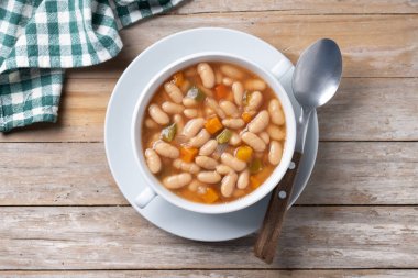 Tahta masada sebzeli beyaz fasulye çorbası. Üst görünüm