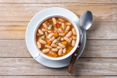 Tahta masada sebzeli beyaz fasulye çorbası. Üst görünüm