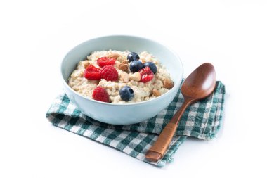 Beyaz arka planda yulaf lapası, ahududu, yaban mersini ve badem.