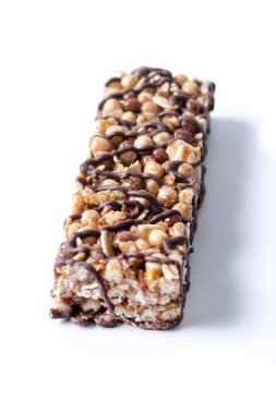 Sağlıklı müsli çikolataları beyaz arka planda izole edilmiş fındık ve siyah çikolata.